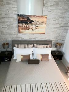 a bedroom with a bed with pillows and a brick wall at Euphoria Skiathos in Skiathos