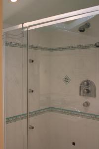 W łazience znajduje się prysznic ze szklanymi drzwiami. w obiekcie Les charmes de Vincent - le loft Cabernet w mieście Fronsac