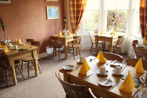 a dining room with tables and chairs with yellow napkins on them at The Grove FREE ON SITE PARKING in Weston-super-Mare