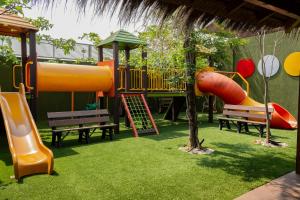 einen Spielplatz mit Rutsche und Bänken in einem Park in der Unterkunft Hotel Los Alpes Cipreses in Asunción