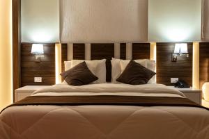 a bedroom with a large bed with two lamps on it at Hotel Los Alpes Cipreses in Asuncion