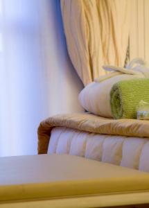 Grand Hotel Terme & SPA في تْشيانشانو تيرمي: كومة من المناشف تجلس على رأس سرير