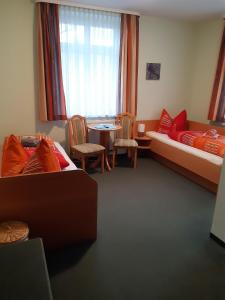 a room with two beds and a table and chairs at Pension Schöne in Großröhrsdorf