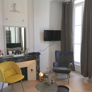 een woonkamer met 2 stoelen en een open haard bij L'ORATOIRE 2 in La Rochelle