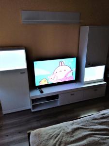 a tv sitting on a entertainment center in a bedroom at Studio Daola in Gdańsk