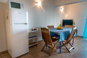 a kitchen with a blue table and a refrigerator at T2B Lagon Austral "parenthèse australe" in Saint-Pierre