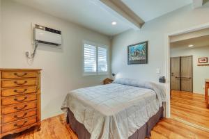 a bedroom with a bed and a dresser and a window at Monsarrat Apt. C in Honolulu