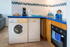 a kitchen with a washing machine and a sink at T2B Lagon Austral "parenthèse australe" in Saint-Pierre