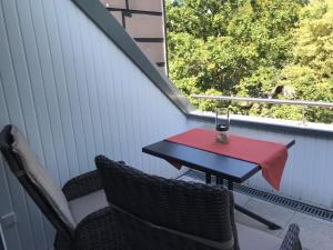 ein Tisch und Stühle auf einer Veranda mit einer roten Serviette in der Unterkunft Fewo im Josefinum in Bad Sassendorf