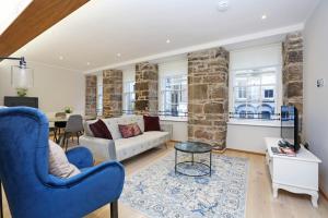 a living room with a couch and a table at ALTIDO Newly Refurbished Apartment on the Historic Royal Mile in Edinburgh