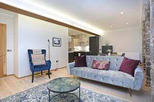 sala de estar con sofá y silla en ALTIDO Newly Refurbished Apartment on the Historic Royal Mile, en Edimburgo