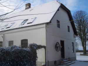 a white house with snow on the roof at Lindenhof in Ahneby