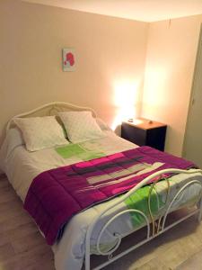 łóżko z kolorową kołdrą w sypialni w obiekcie Chambres d'Hôtes Le Clos du Murier w mieście Villefranche-de-Rouergue