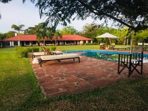 une cour avec une piscine, une table et un banc dans l'établissement Aguapé Lodge, à Colonia Carlos Pellegrini