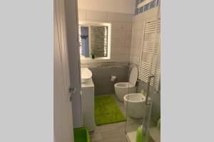 łazienka z 2 toaletami, umywalką i prysznicem w obiekcie Stefano Rho Apartment Near RHO-FIERA and MILANO w mieście Rho