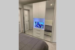 sypialnia z telewizorem, łóżkiem i lustrem w obiekcie Stefano Rho Apartment Near RHO-FIERA and MILANO w mieście Rho