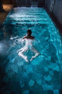 a person swimming in a pool of water at Petit Hôtel Confidentiel in Chambéry