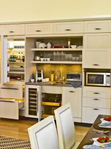 a kitchen with white cabinets and a table in it at White Elephant Hotel in Nantucket