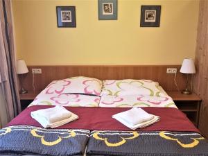 a bedroom with a bed with two pillows on it at Apartment Hanspaulka Garden in Prague