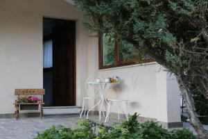 - une table et des chaises sur la terrasse couverte d'une maison dans l'établissement B&B Greenmind, à San Dorligo della Valle