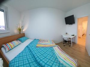 Dormitorio con cama, escritorio y TV en Ljubljana sky view, en Liubliana