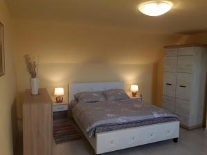 a bedroom with a bed and two night stands and two lamps at Apartmány Matilda in Pribylina