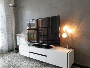 ル・ラヴァンドゥーにあるLes Cycladesの白いキャビネットのテレビ付きの客室です。