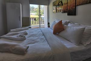 a large bed with white sheets and pillows on it at Vista Apartment Mariners Cabin in Nuwara Eliya