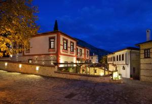 a building on a cobblestone street at night at Orologopoulos Mansion Luxury Hotel in Kastoria