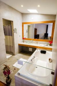 a bathroom with a large white tub and a mirror at La Hostería Boutique Hotel in Arequipa