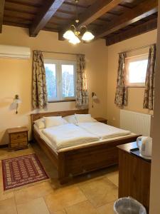 A bed or beds in a room at Aurora Panzió