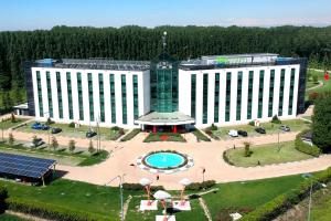 塞塔拉的住宿－ibis Styles Milano Est Settala，享有带游泳池的大型建筑的顶部景色