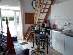 a kitchen with a staircase and a counter with stools at Chambres d'Hotes Elvire et Laurent Barbey in Sainte-Marie-du-Mont