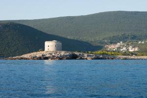a building on an island in the middle of the water at Hotel Art Media in Herceg-Novi