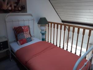 1 cama con manta roja y lámpara en Chambres d'Hotes Elvire et Laurent Barbey, en Sainte-Marie-du-Mont