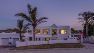 a white house with palm trees in front of it at The White House in Port Elizabeth