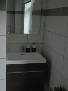 een badkamer met een witte wastafel en een spiegel bij B&B Les Tchéous in La Gleize