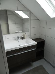 een badkamer met een wastafel en een spiegel bij B&B Les Tchéous in La Gleize