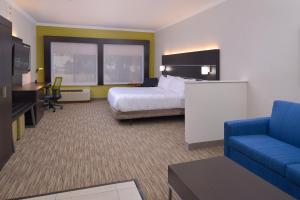 a hotel room with a bed and a couch and a tv at Holiday Inn Express & Suites Austin NW - Lakeline, an IHG Hotel in Austin