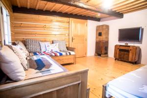 a living room with a couch and a flat screen tv at Chalupa u Studánky in Spálené