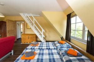 Hügelhus في كلوستر: غرفة نوم مع سرير ووسائد برتقالية عليه