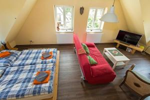 a living room with a bed and a red couch at Hügelhus in Kloster