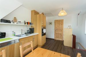 a kitchen with wooden cabinets and a sink and a refrigerator at Hügelhus in Kloster
