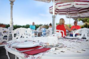 una mesa blanca con platos y servilletas. en Le Château de Mei Lese, en La Croix-Valmer