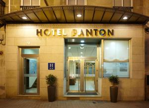 a hotel entrance with two potted plants in front of it at Hotel Pantón in Vigo