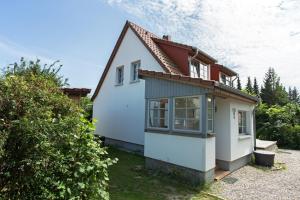 a small white house with a red roof at Hügelhus in Kloster