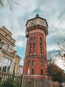 um edifício alto de tijolos vermelhos com uma torre de relógio em Apartamenty w Wieży em Świdnica