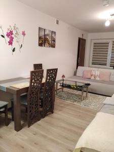 sala de estar con mesa, sillas y sofá en u Gosi, en Krynica-Zdrój