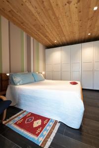 a bedroom with a large white bed with a wooden ceiling at Casa Monet in Saint Vincent