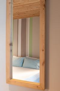 a mirror reflecting a bed in a room at Casa Monet in Saint Vincent